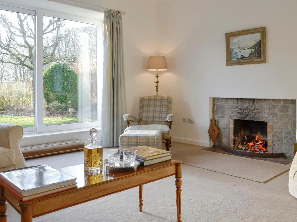 a living room with a couch and a fireplace at The Coach House in Alford