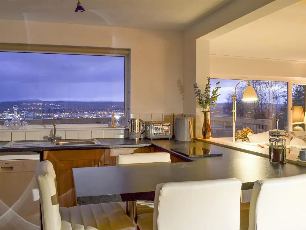 a kitchen with a table and a large window at Balnacraig in North Kessock