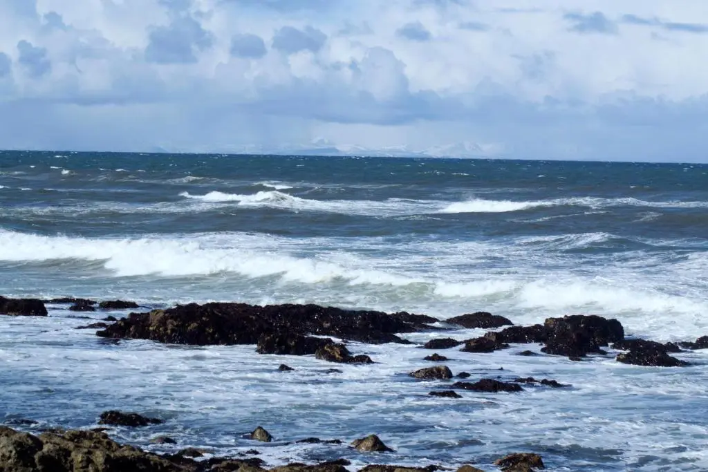 a beach with rocks and waves in the ocean at Stotfield Hotel in Lossiemouth