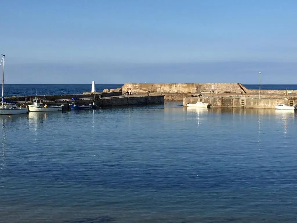 a group of boats docked in a body of water at Jebel in Cullen