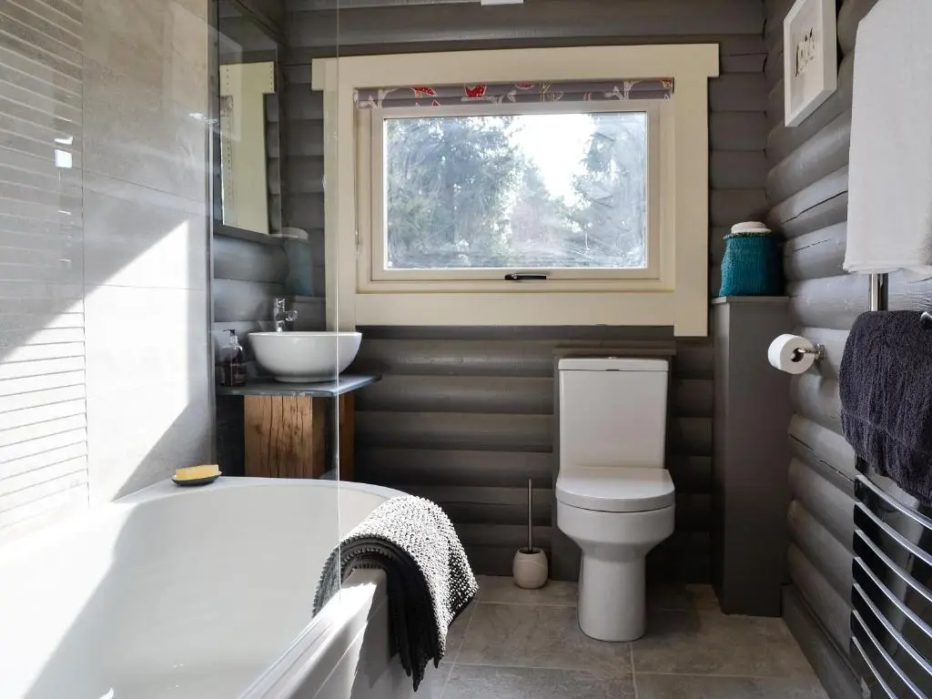 a bathroom with a tub and a toilet and a window at Glen Hideaway in Balnald