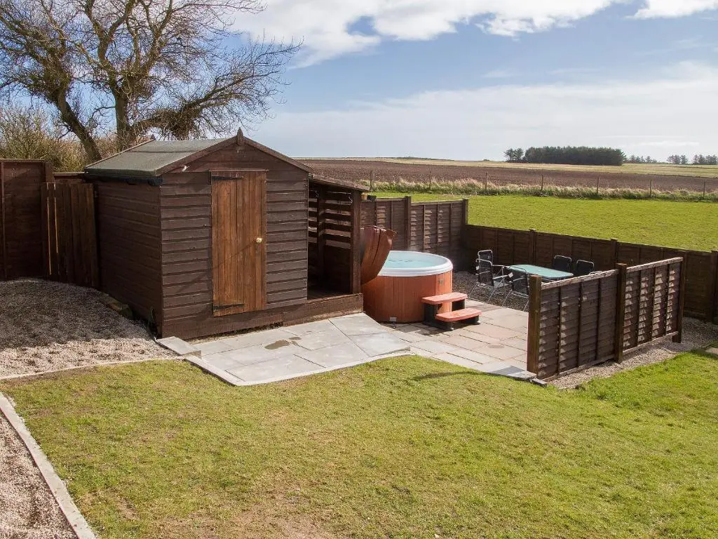a small wooden shed with a bench and a table at Sheaf Dale in Portmahomack
