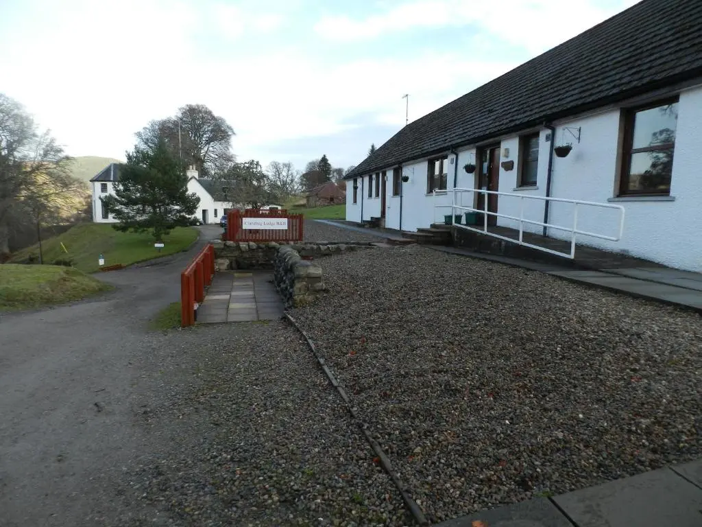 a building with a lot of gravel in front of it at Clunebeg Lodge in Drumnadrochit