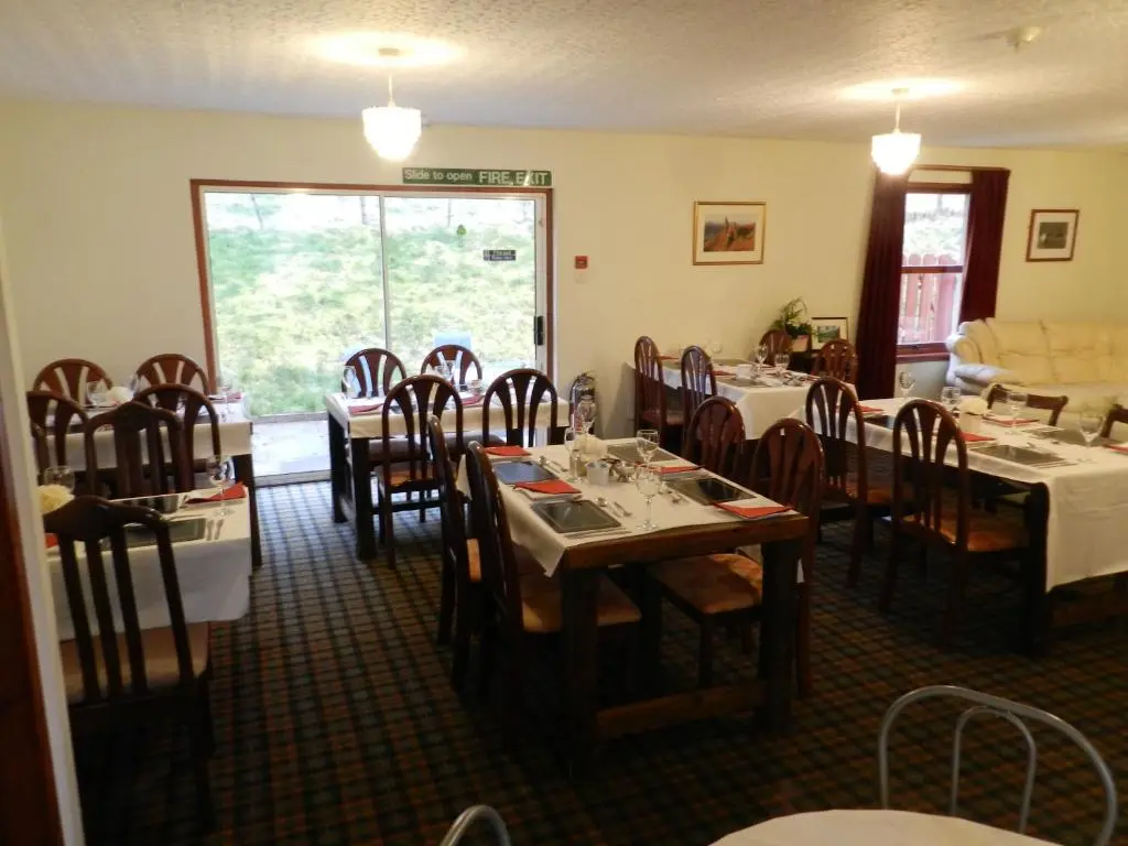 a dining room with tables and chairs in a restaurant at Clunebeg Lodge in Drumnadrochit