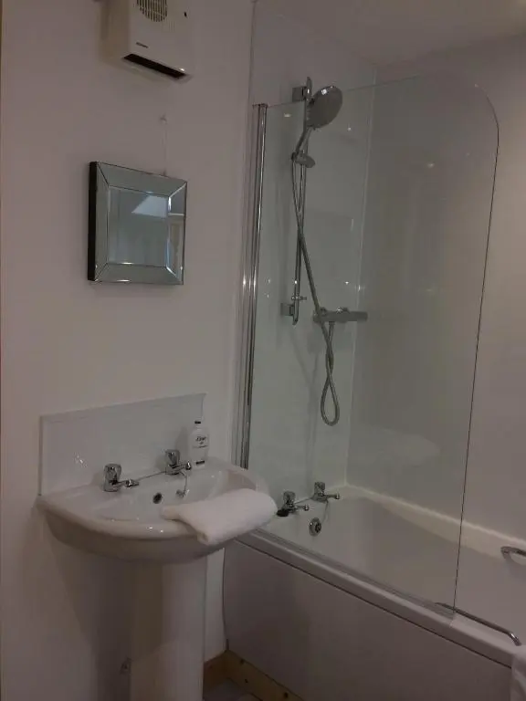 a bathroom with a sink and a shower and a tub at Millburn Apartments in Inverness