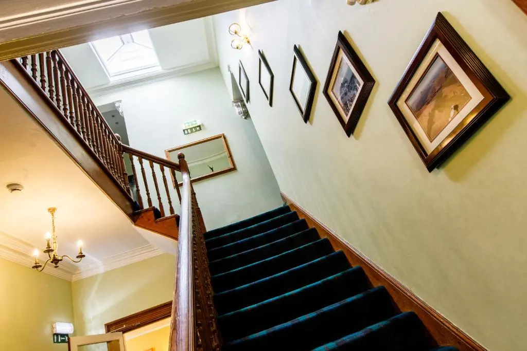 a staircase in a house with paintings on the walls at No 45, Ballater in Ballater