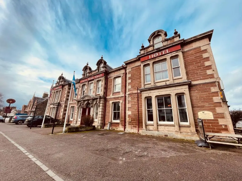 an old brick building on the side of a street at Lovat Arms Hotel in Beauly