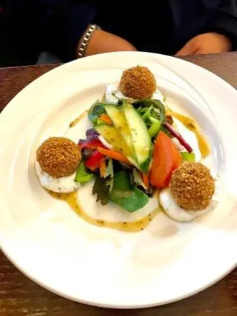 a white plate with a salad on a table at Lovat Arms Hotel in Beauly