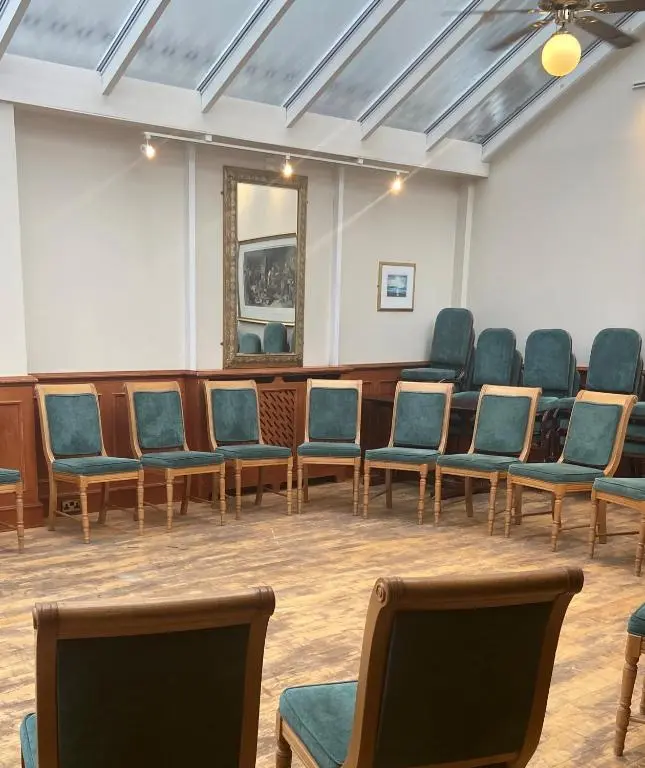 an empty waiting room with chairs and a mirror at Lovat Arms Hotel in Beauly