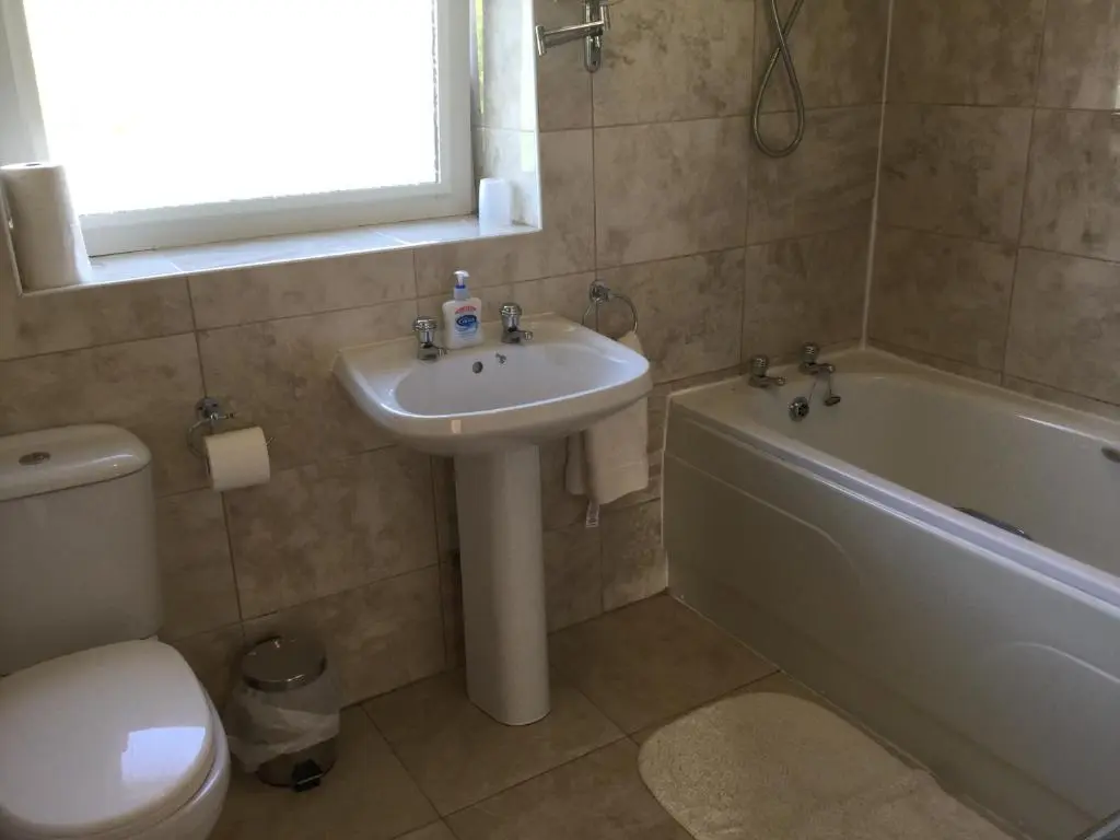 a bathroom with a sink and a tub and a toilet at 3 Bedroom Culduthel House Free Parking in Inverness