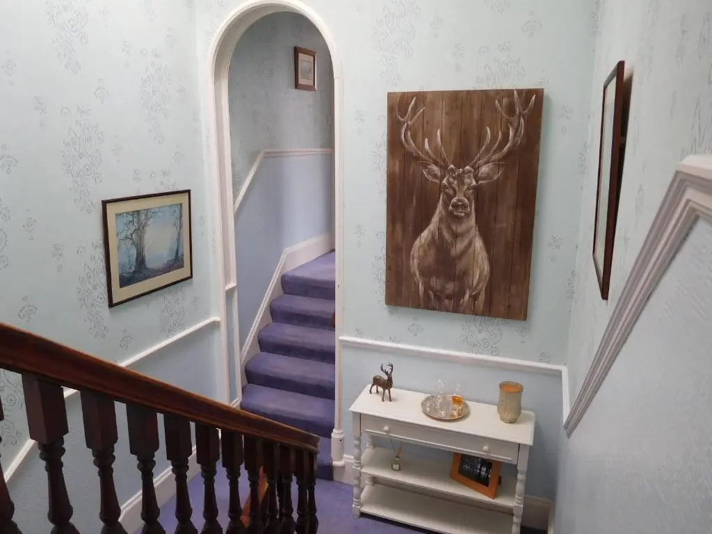 a staircase with a painting of a deer on the wall at The Castle B&B in Inverness