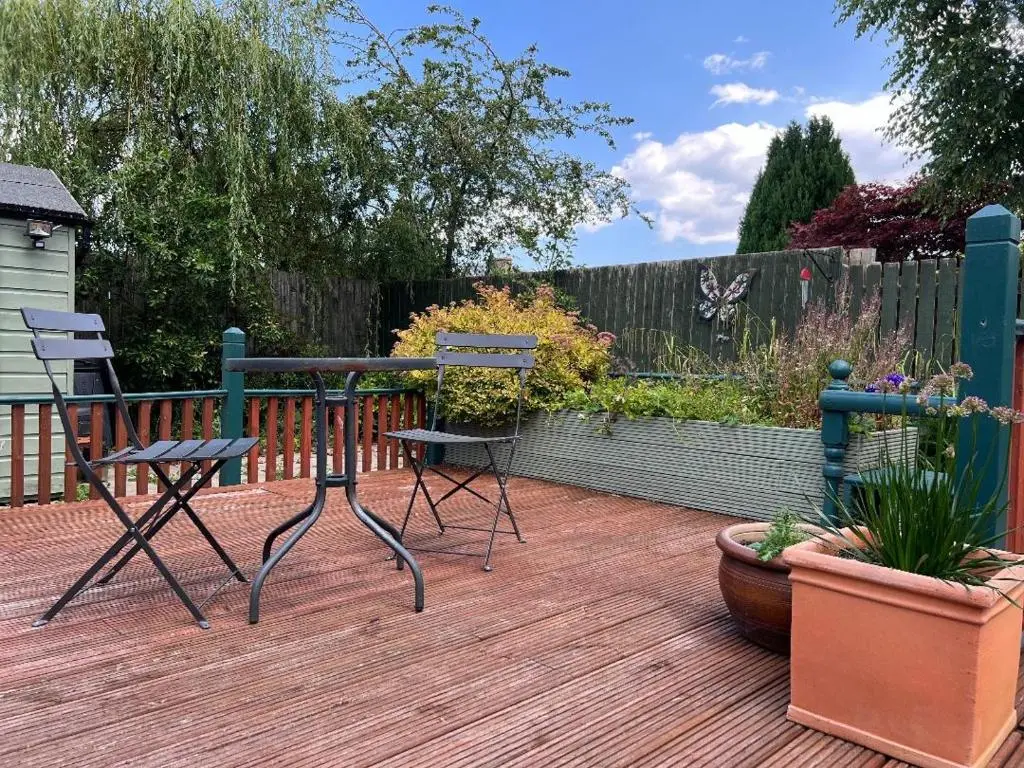 two chairs and a table on a wooden deck at The Castle B&B in Inverness