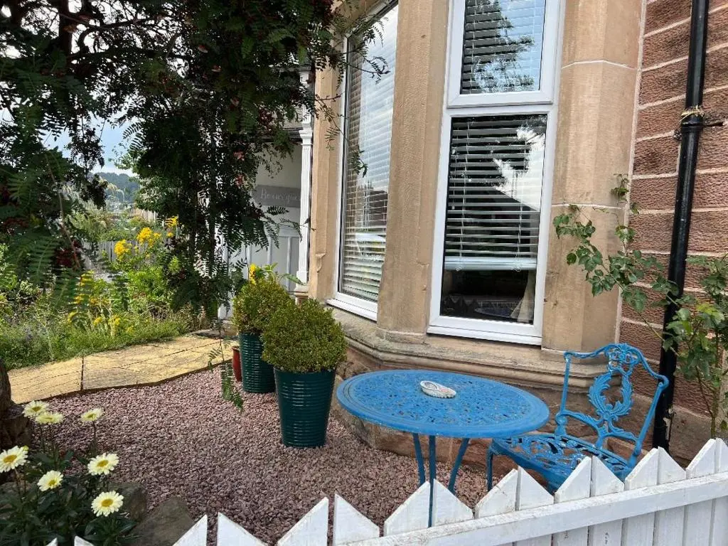 a blue bench sitting in front of a house at The Castle B&B in Inverness