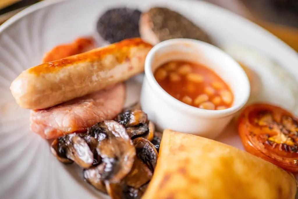a plate of food with a hot dog and mushrooms at Maryculter House in Maryculter