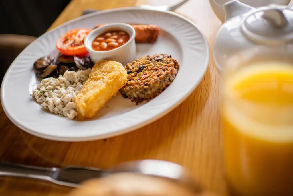 a plate of food on a table next to a glass of orange juice at Maryculter House in Maryculter