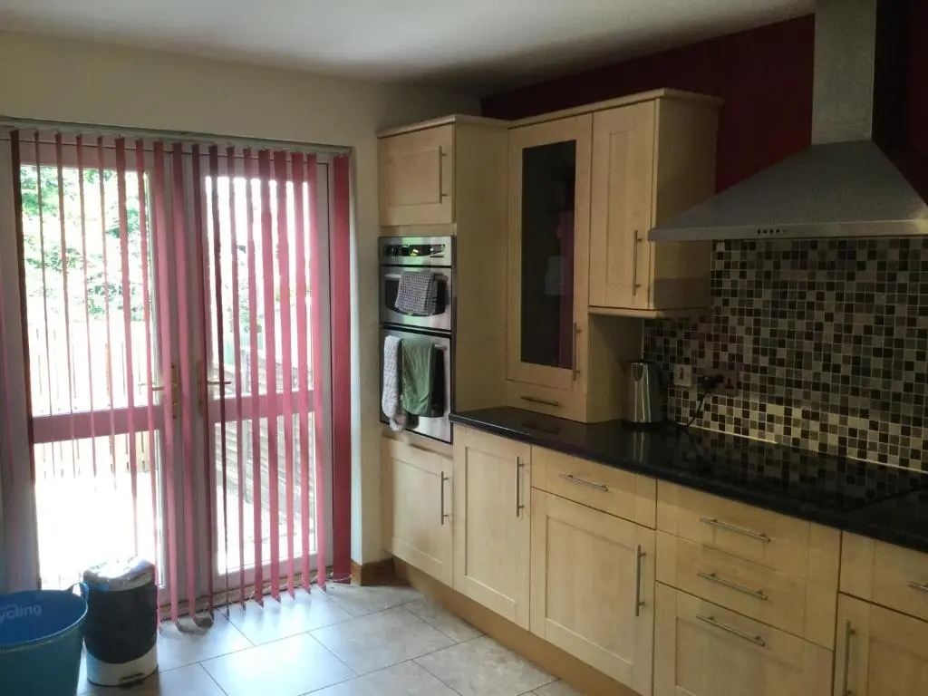 a kitchen with wooden cabinets and a large window at Four-Bedroom House - Stratherrick Free Parking in Inverness