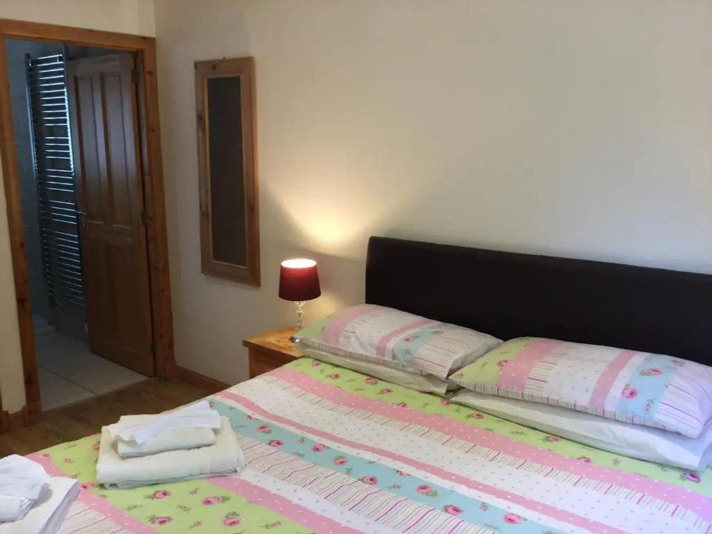 a bedroom with a bed with a pink and white bedspread at Four-Bedroom House - Stratherrick Free Parking in Inverness