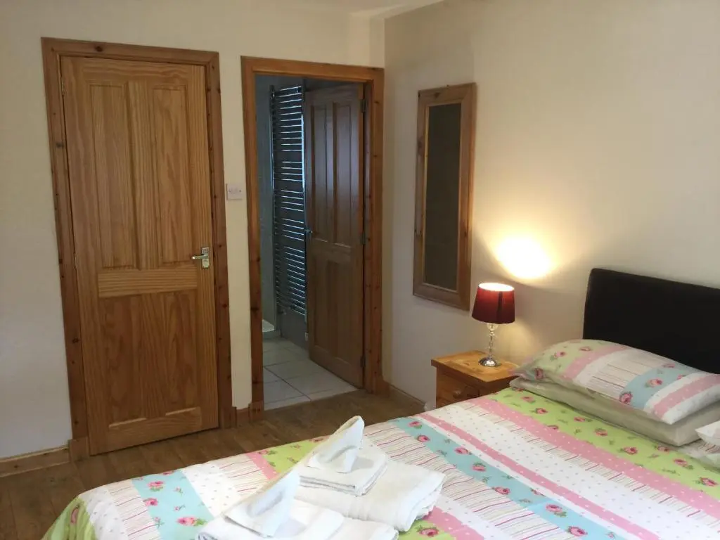 a bedroom with a bed and a door to a hallway at Four-Bedroom House - Stratherrick Free Parking in Inverness