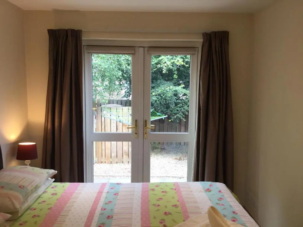 a bedroom with a bed and a sliding glass door at Four-Bedroom House - Stratherrick Free Parking in Inverness