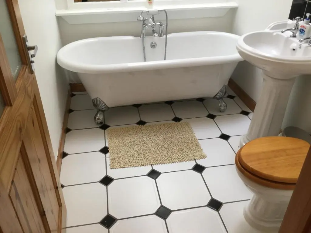 a bathroom with a tub and a toilet and a sink at Four-Bedroom House - Stratherrick Free Parking in Inverness