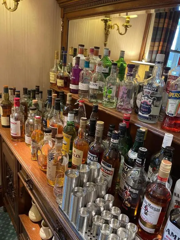 a shelf filled with lots of bottles of alcohol at Ravenscourt House, Guest House in Grantown on Spey