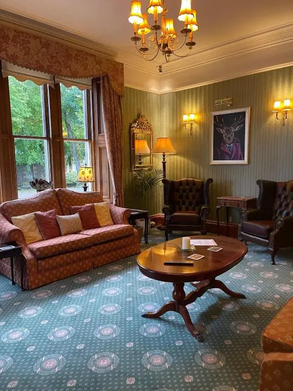 a living room with a couch and a table at Ravenscourt House, Guest House in Grantown on Spey
