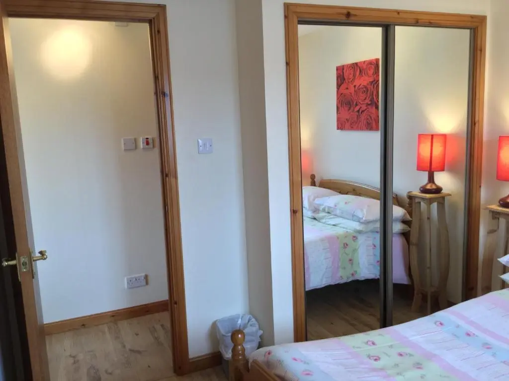 a bedroom with a mirror and a bed in a room at One-Bedroom Apartment - Wyvis Free Parking in Inverness