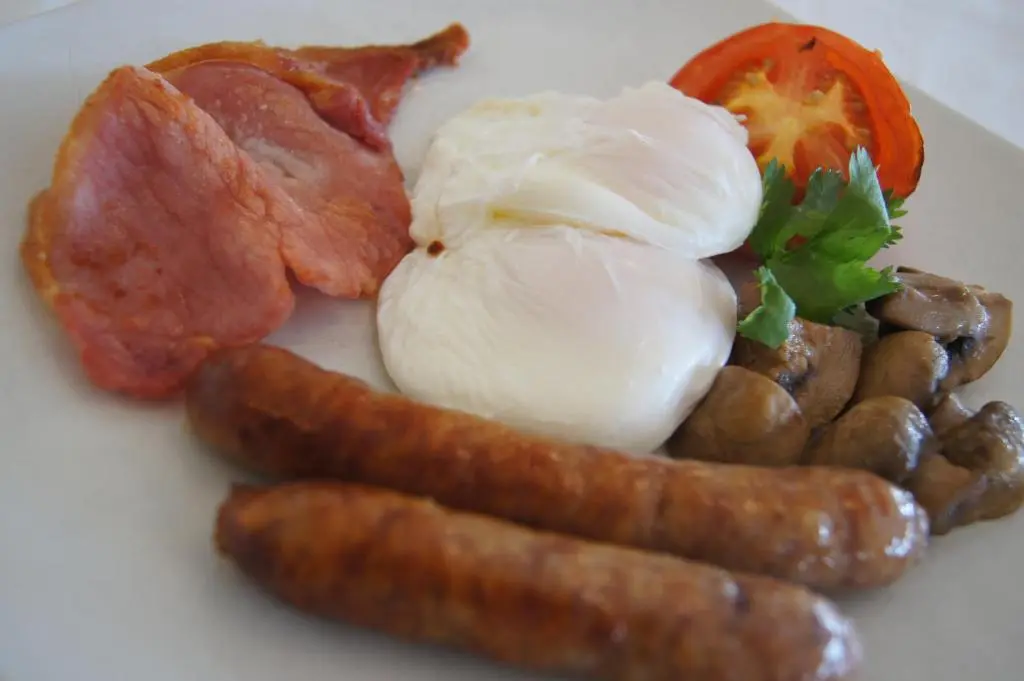 a plate of breakfast food with eggs bacon and mushrooms at Laichmoray Hotel in Elgin