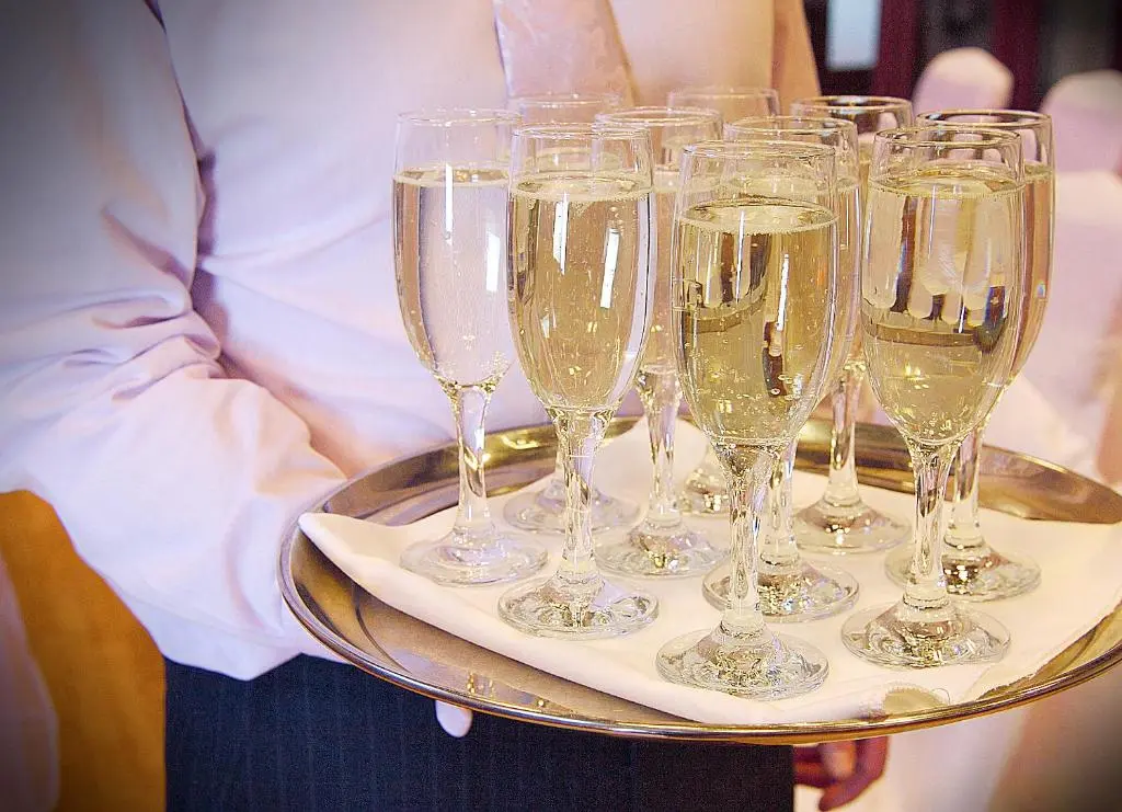 a waiter holding a tray of champagne glasses at Laichmoray Hotel in Elgin