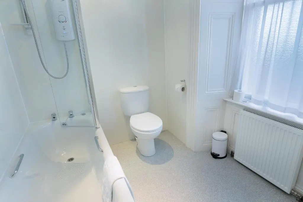 a white bathroom with a toilet and a shower at Laichmoray Hotel in Elgin