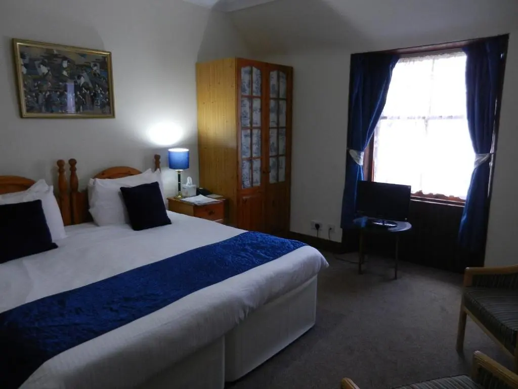 a hotel room with a large bed and a window at Mansfield Castle Hotel in Tain