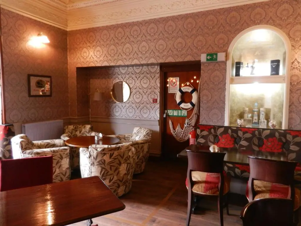 a restaurant with tables and chairs and a mirror at Mansfield Castle Hotel in Tain