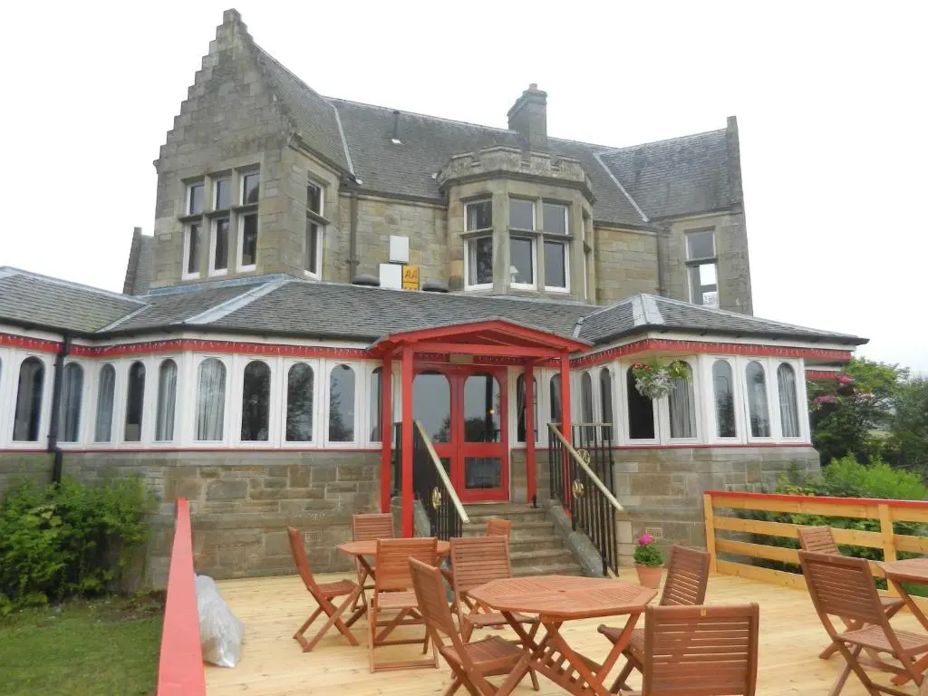 a house with tables and chairs in front of it at Morangie Hotel Tain in Tain