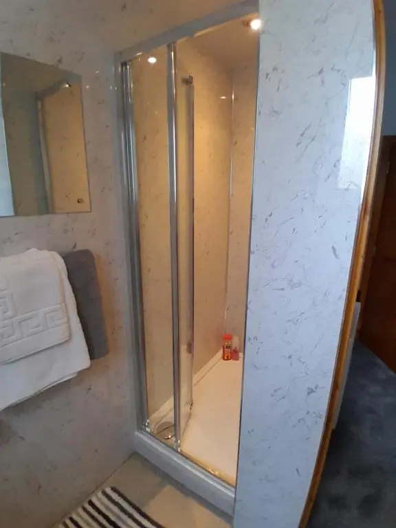 a shower with a glass door in a bathroom at Fairfield Townhouse Guest House in Inverness