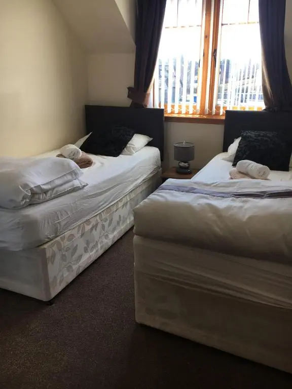 two beds sitting in a room with a window at Cairngorm Mountain View in Aviemore