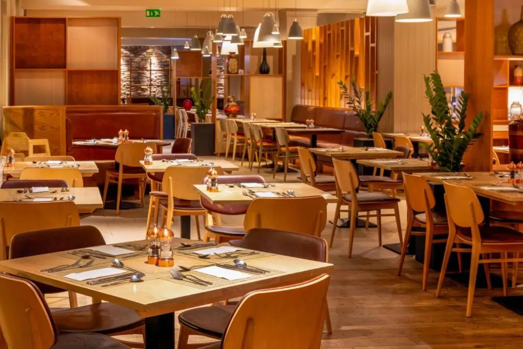 a restaurant dining room with tables and chairs at Coylumbridge Resort Hotel in Aviemore