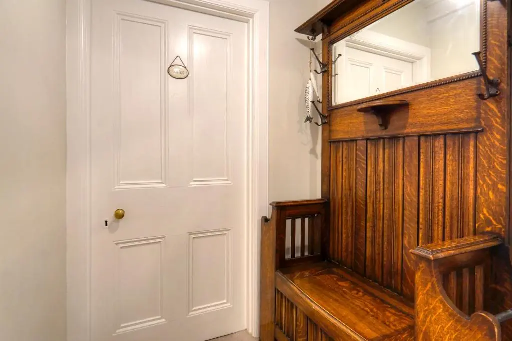 a hallway with a white door and a wooden wall at The Tannochbrae in Dufftown