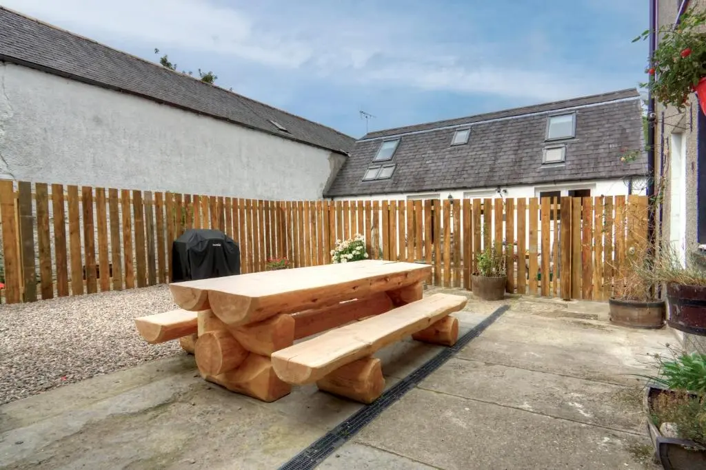 a wooden bench sitting in front of a fence at The Tannochbrae in Dufftown