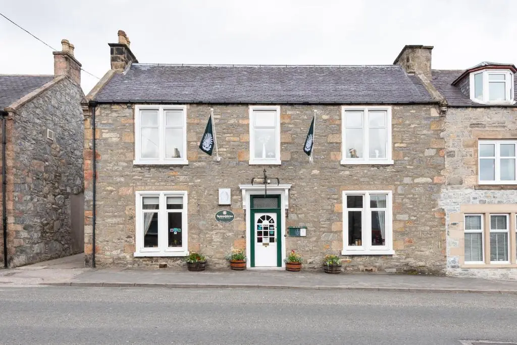 an old stone building with a green door at The Tannochbrae in Dufftown