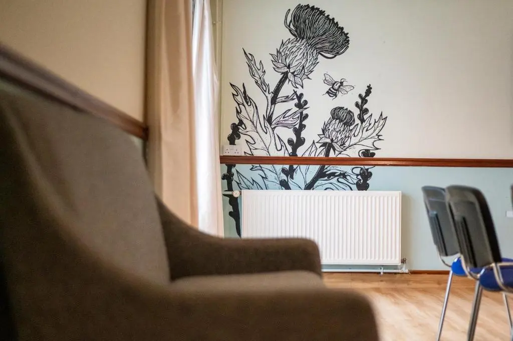a wall with a flower stencil on it at Inverness Youth Hostel in Inverness