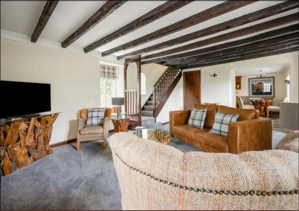 a living room with two couches and a tv at Loch Ness Cottages in Brackla