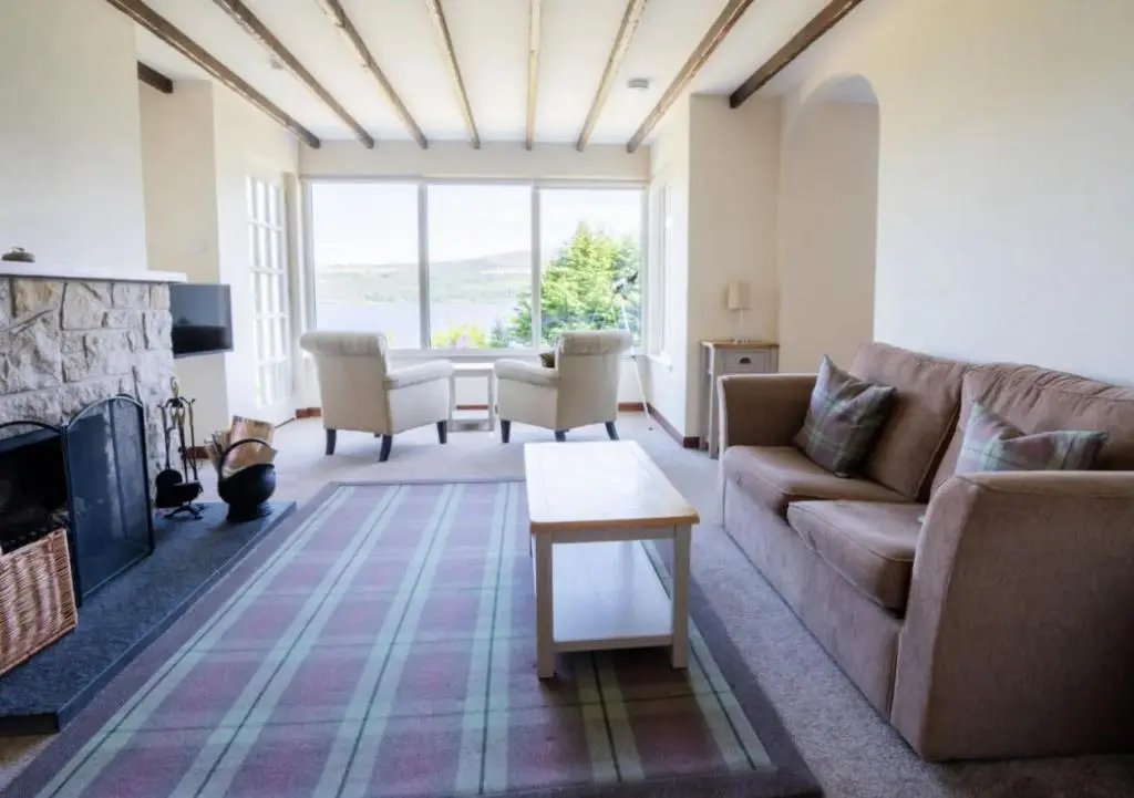 a living room with a couch and a fireplace at Loch Ness Cottages in Brackla