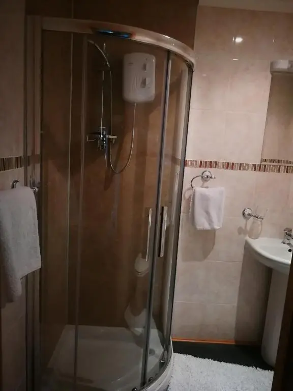 a glass shower in a bathroom with a sink at Granville Guest House in Dyce