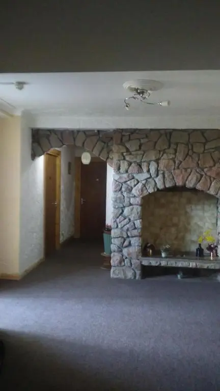 a stone fireplace in a room with a stone wall at Granville Guest House in Dyce