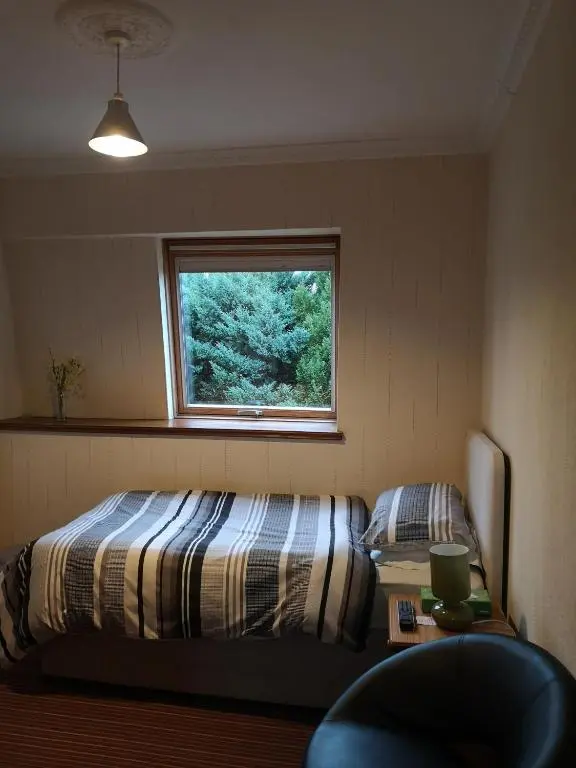 a bedroom with a bed and a window at Granville Guest House in Dyce