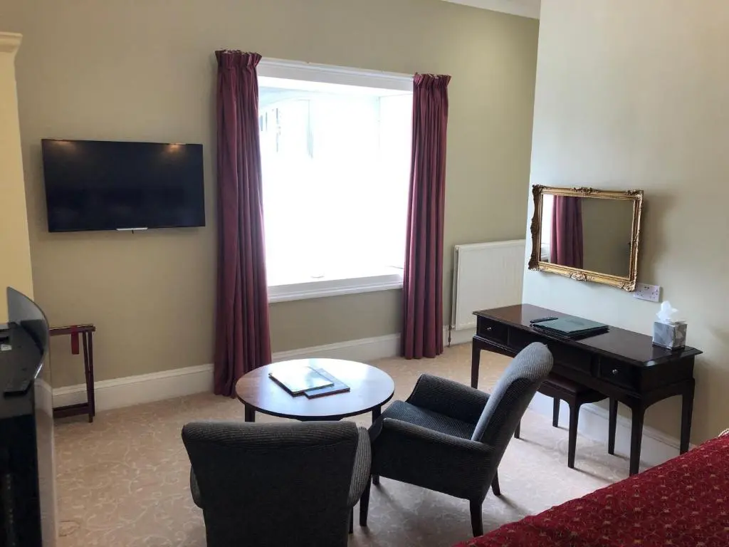 a living room with a desk and a mirror at Coul House Hotel in Contin