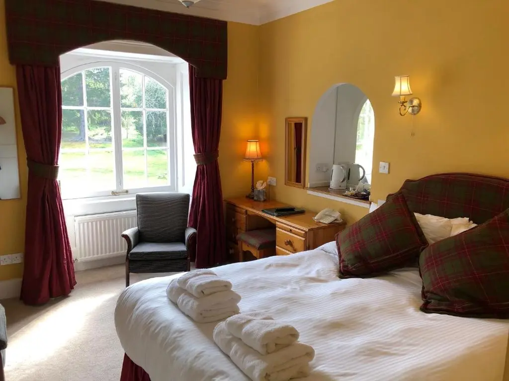 a bedroom with a bed with towels on it at Coul House Hotel in Contin
