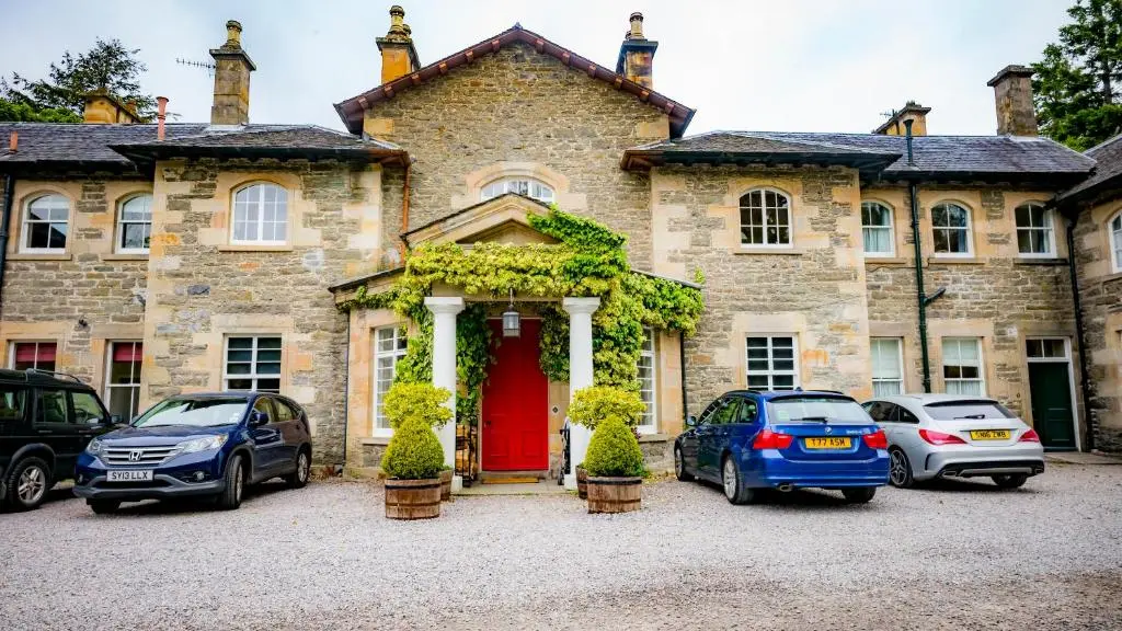 a house with cars parked in front of it at Coul House Hotel in Contin