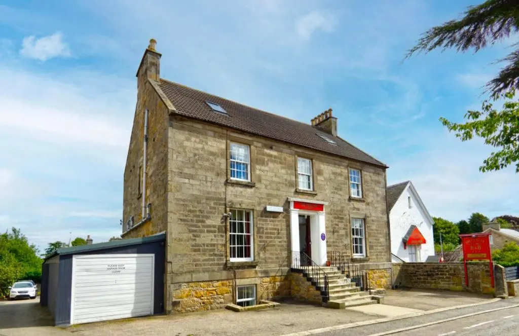 an old brick house with a garage at Southbank Guesthouse in Elgin