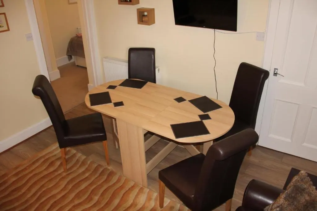 a wooden table and chairs in a room at Reay Street Apartment in Inverness